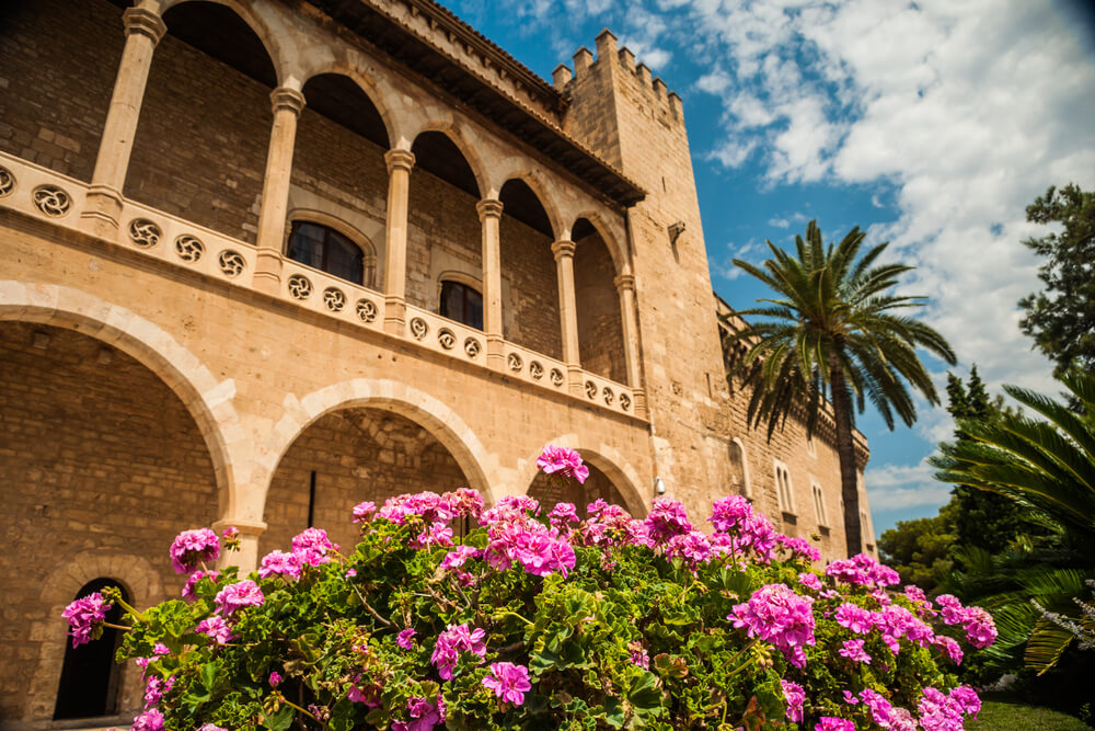 Palacio de Almudaina: A Moorish building with a pink flower bush outside