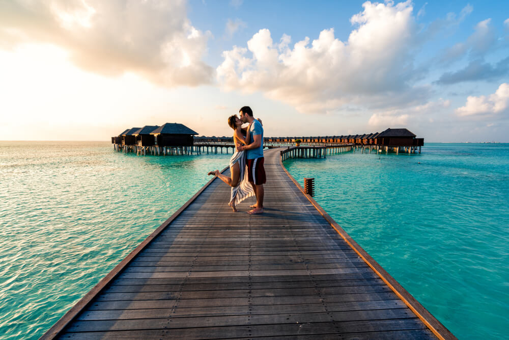 Adults-only hotels in Spain: A couple being romantic on the balcony of Barceló Illetas Albatros
