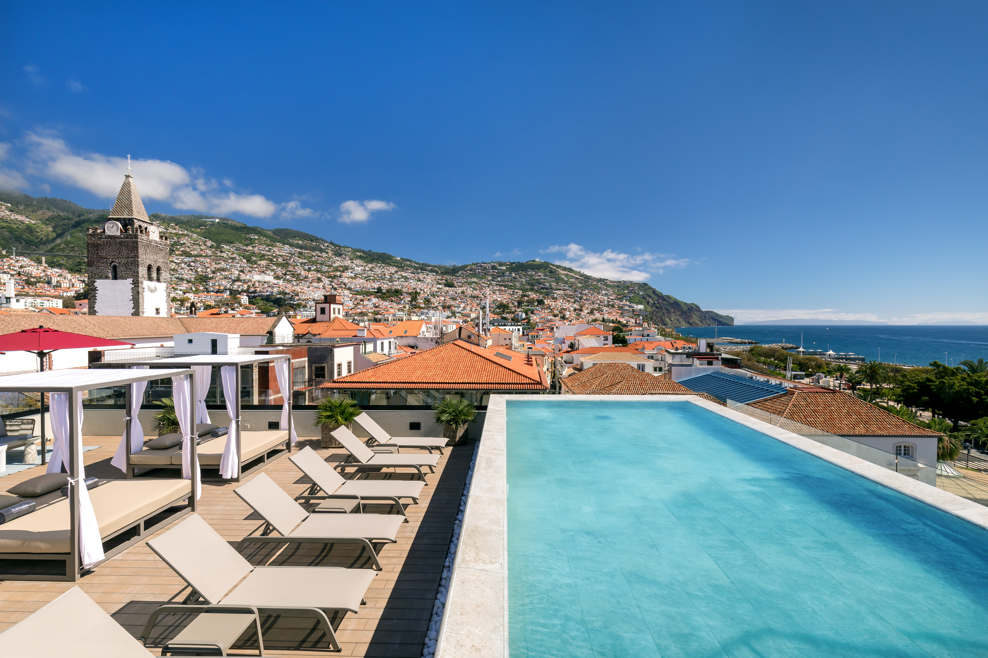 Babymoon-Urlaubsziele: Blick auf die Stadt Funchal von einer Terrasse mit balinesischen Betten.