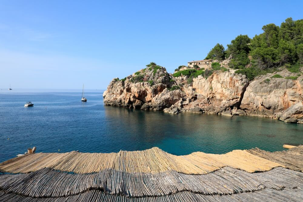 Cala Deia: Views of the ocean and a boat from the Cala Deia cove coastline 