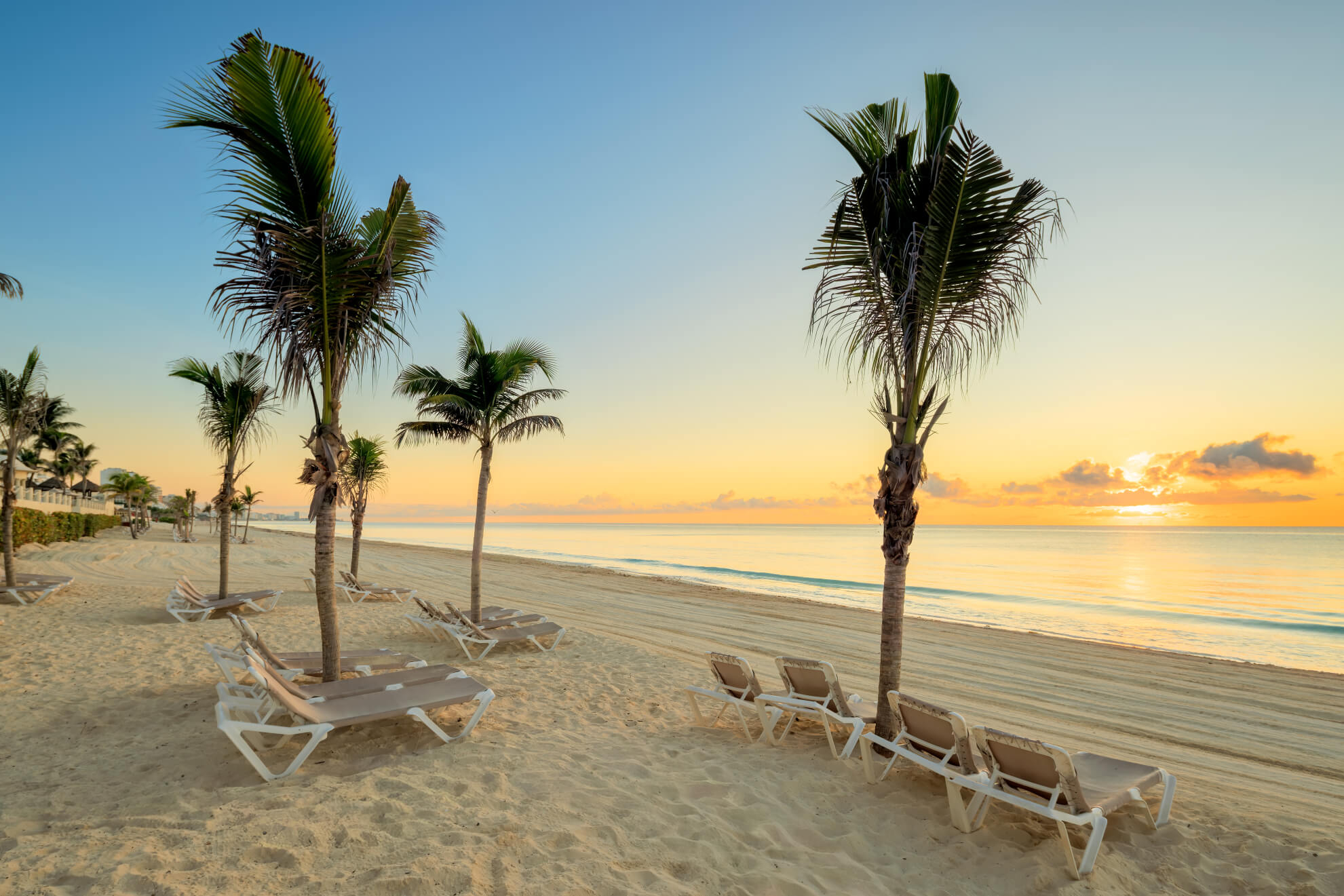 Liegestühle auf dem Playa Marlín in Cancún bei Morgengrauen.