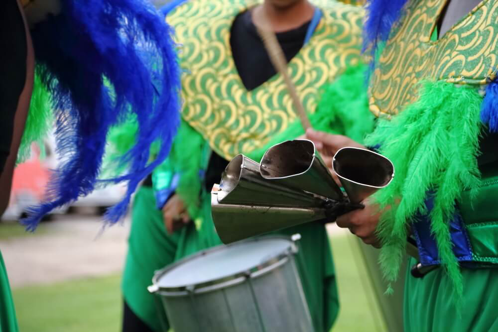 Batucadas: A group of people dressed in green costumes with instruments