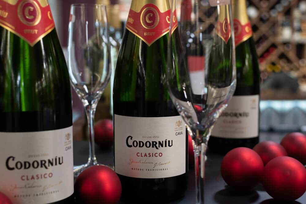 Codorníu: Sparkling wine bottles lined up with Christmas decorations