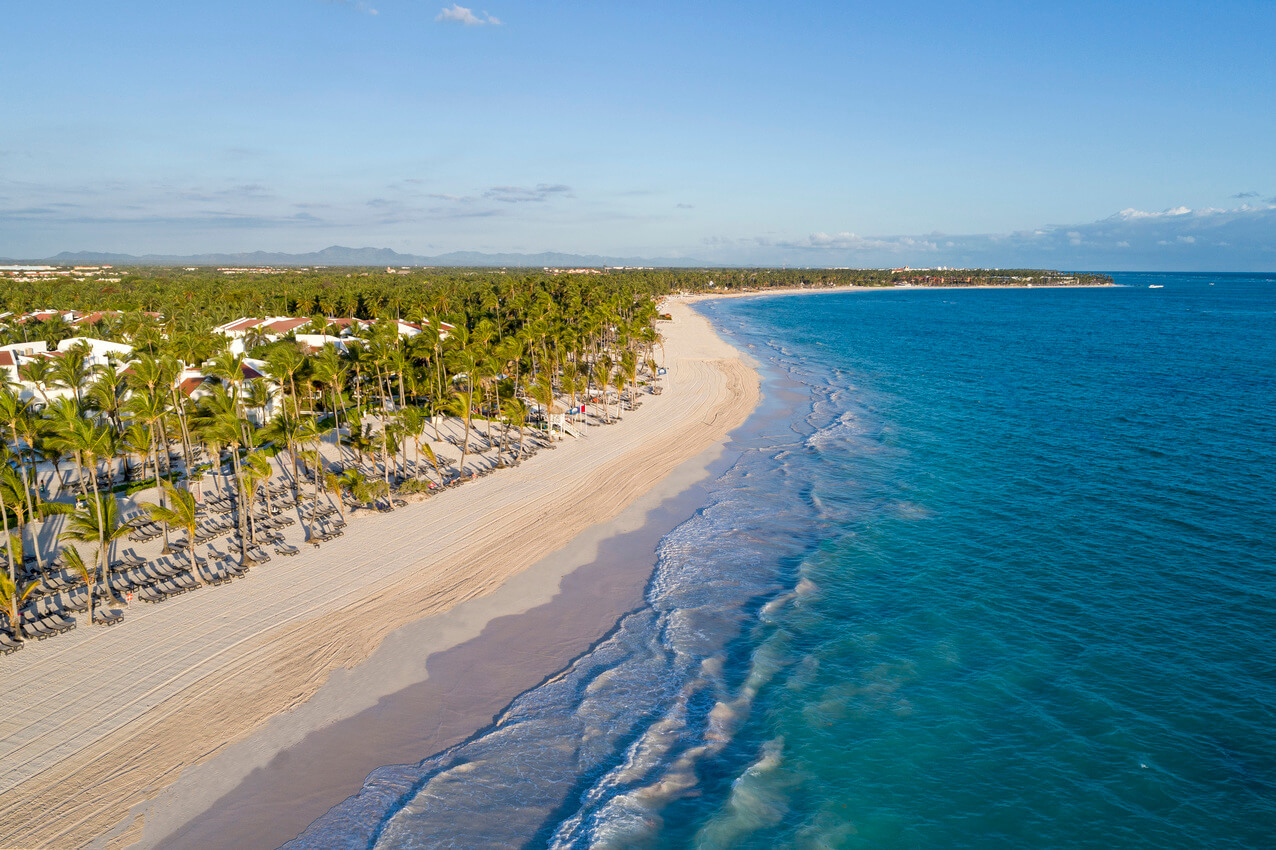 Punta Cana: A long white sand beach and topaz blue waters with palm trees