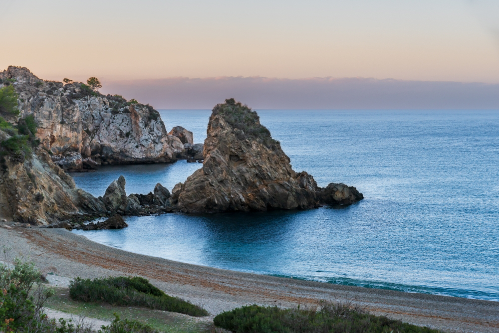 Maro: Sun setting over white sand beach and cliffs