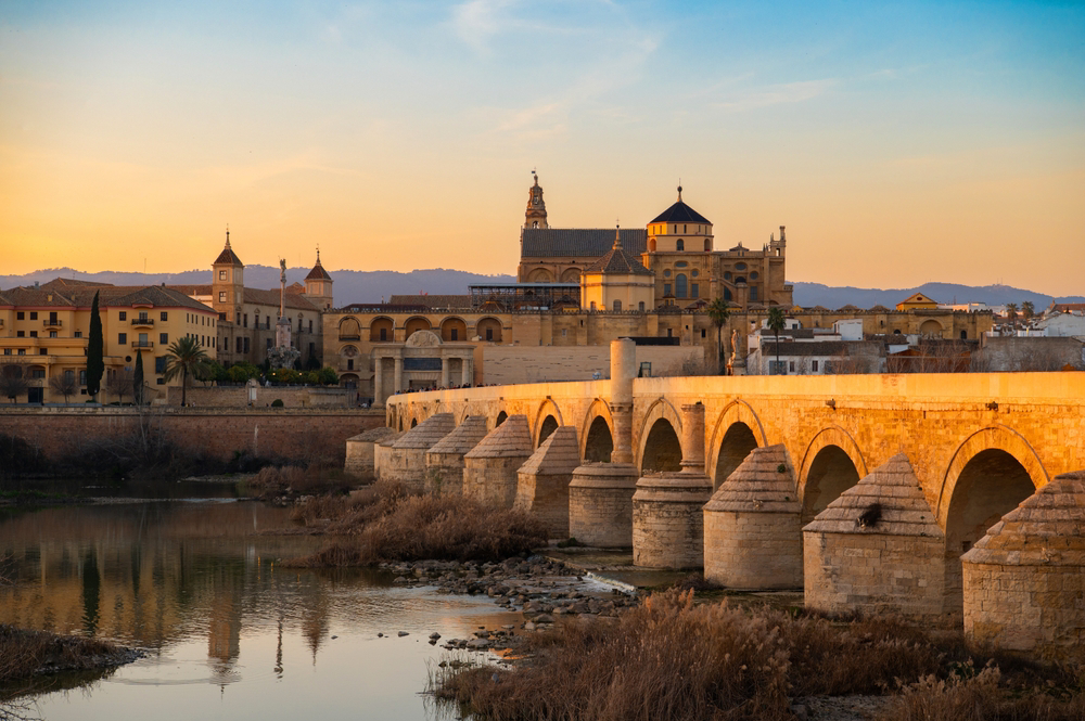 Córdoba: A sunset view of the Roman bridge and the Mesquita in the distance