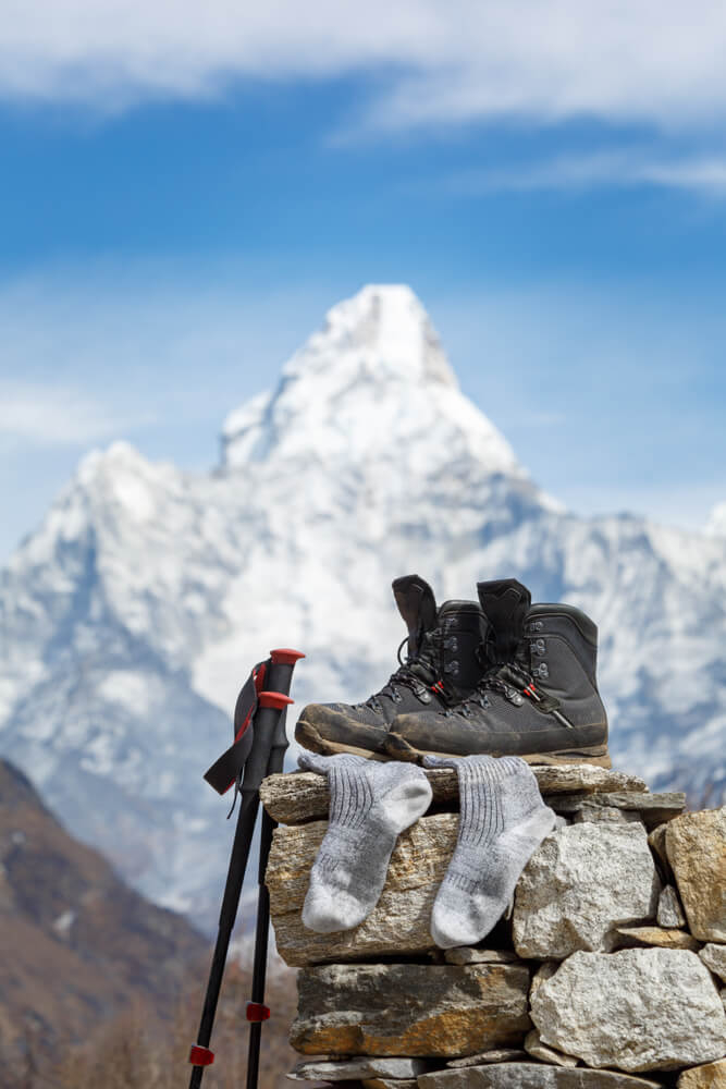 Family hiking holidays: Hiking boots and stick propped up on a wall