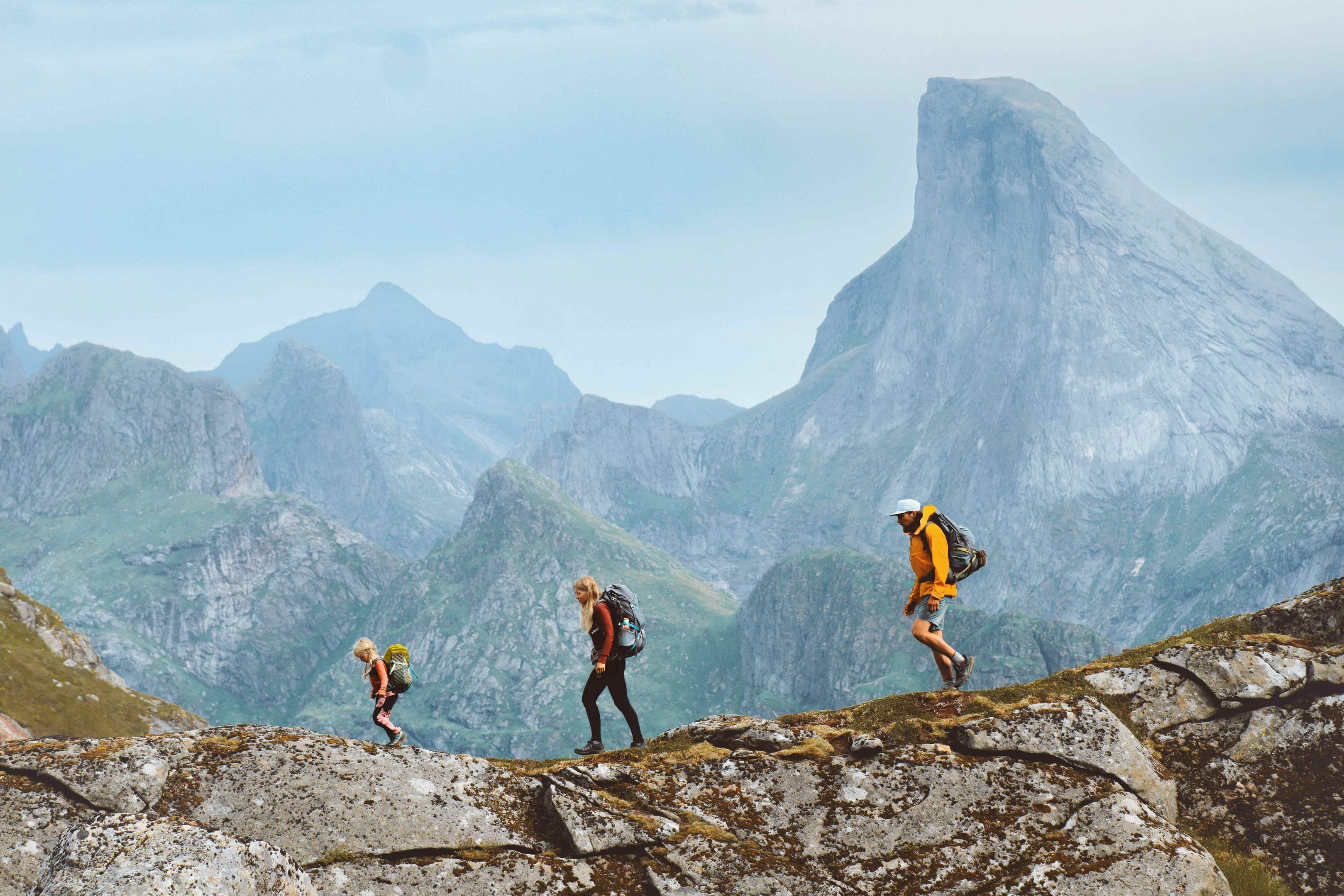 Family hiking holidays: A man, woman and child walking across a mountain