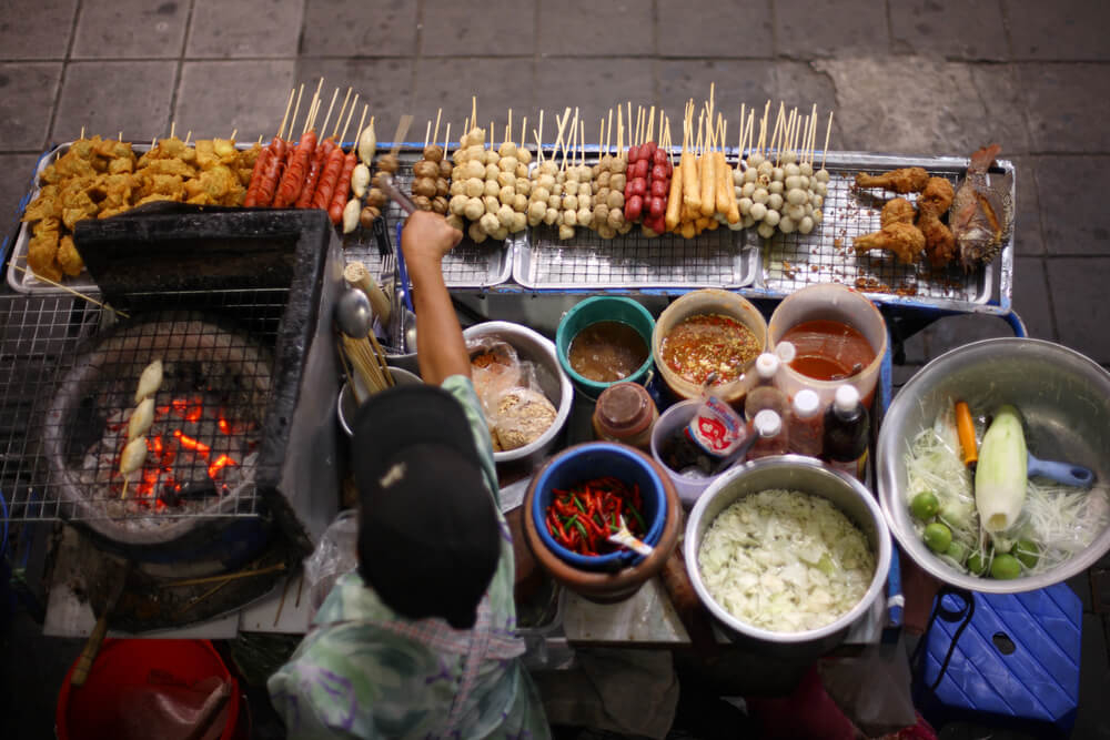 Food in Thailand: A woman cooking Thai food on the street
