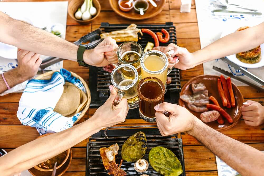 Mexikanisches Bier: Menschen stoßen mit verschiedenen Biersorten an.