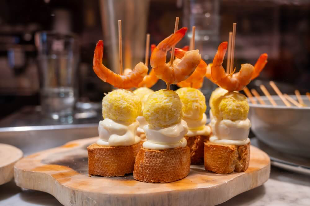 Baskische Pintxos auf einem hölzernen Tablett.