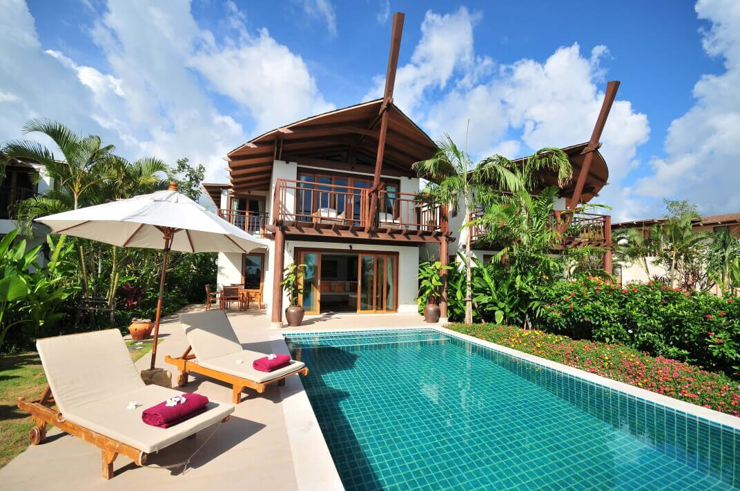 Coconut Island: A white holiday home with a wooden roof, pool and loungers