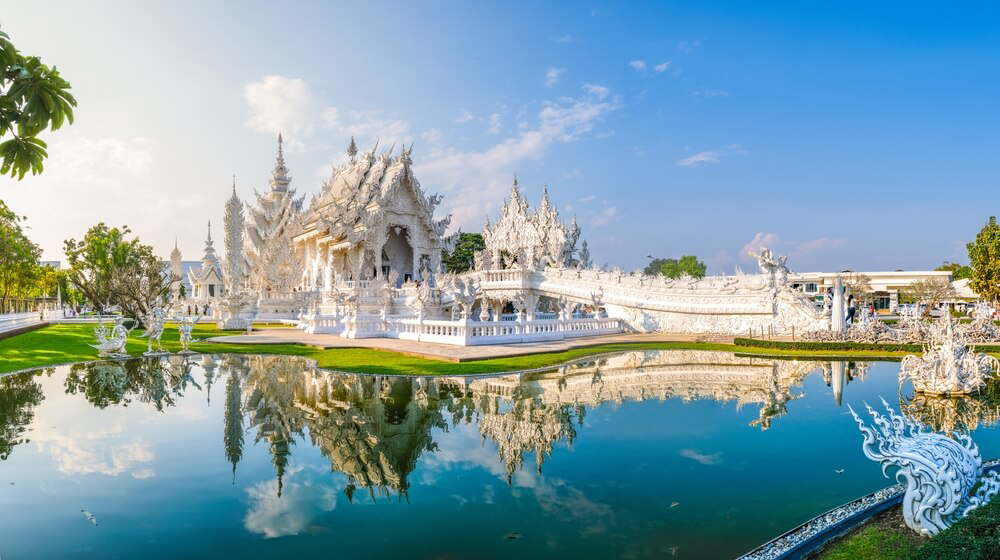 Temples in Thailand: An ornate white temple with a lake
