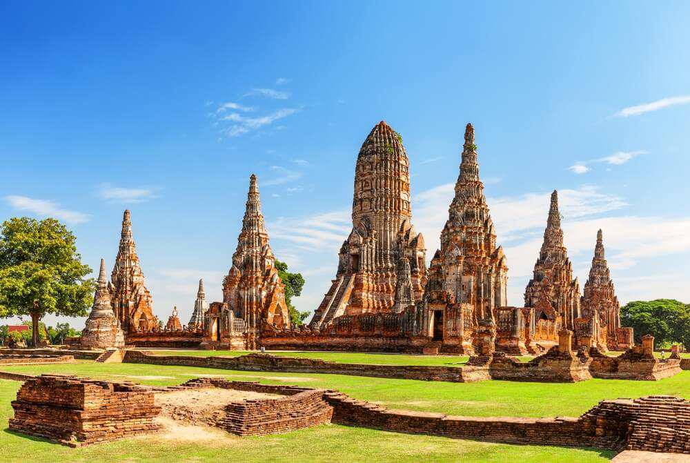Wat Chaiwatthanaram: A red stone ornate temple set in a grassy site