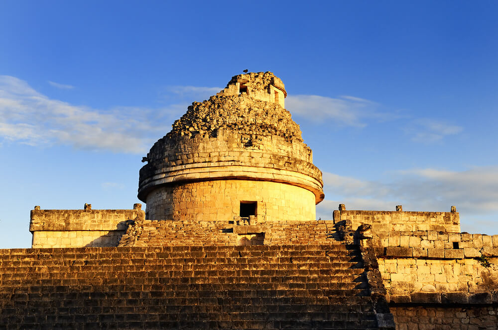 A sunset view of the peak of a pyramid at the Mayan ruins of Chichen Itza.