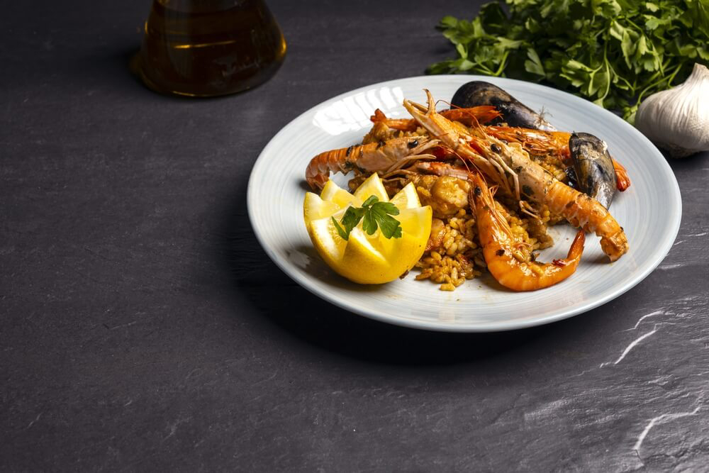 Eine echte valencianische Paella mit Paprika in einer Pfanne.