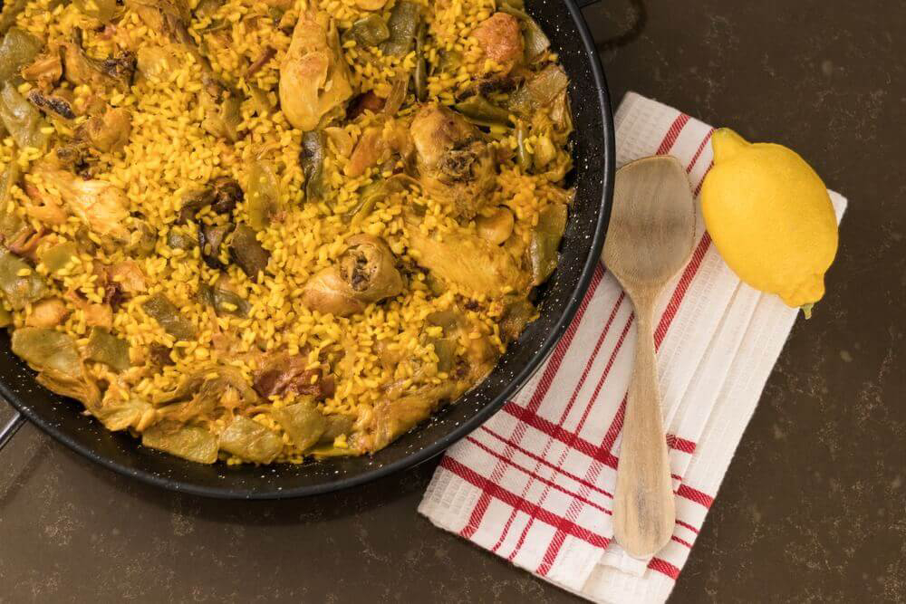 Die authentische valencianische Paella kommt mit wenigen Zutaten aus: Fleisch, Gemüse und Reis.