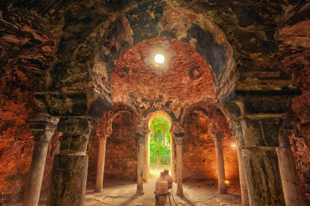 Arab Baths: A red stone domed room with arches and columns